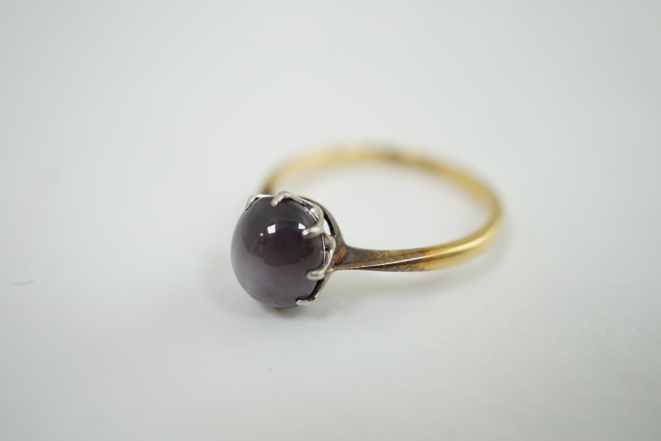 An 18ct, platinum and single stone oval cabochon grey? star sapphire set ring